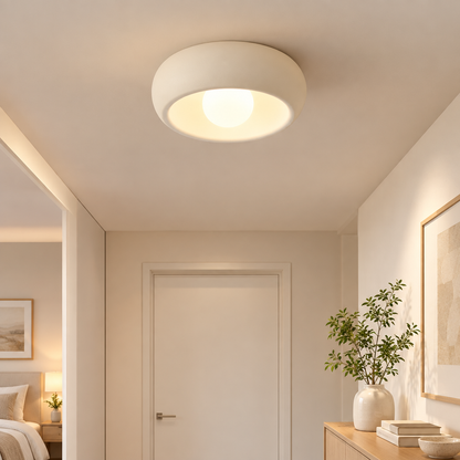 Minimalist circular flush-mount ceiling lamp in a bright hallway